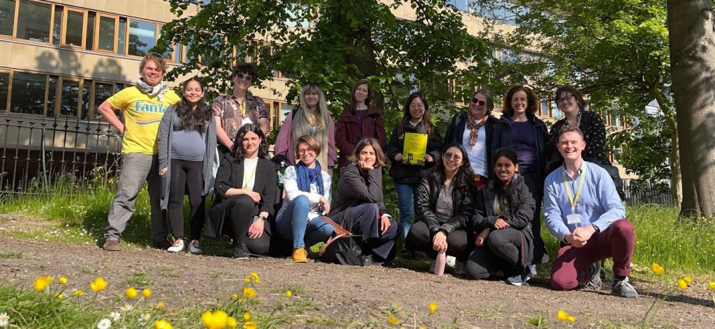 Photo of summer school participants taken on a summer day in a park in front of a university building in Edinburgh